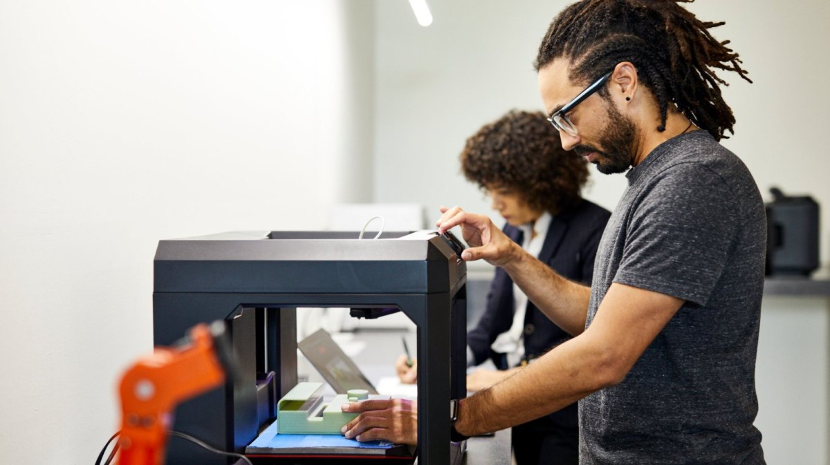 Mann und Frau an einem 3D-Drucker.