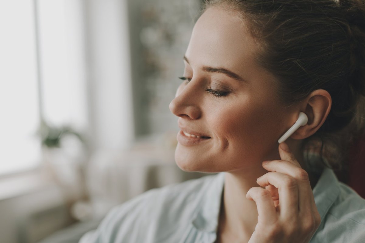 Frau mit AirPods im Ohr.