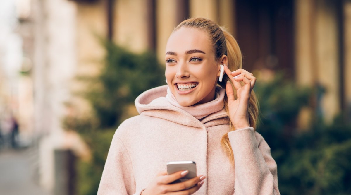 Frau mit AirPods im Ohr.