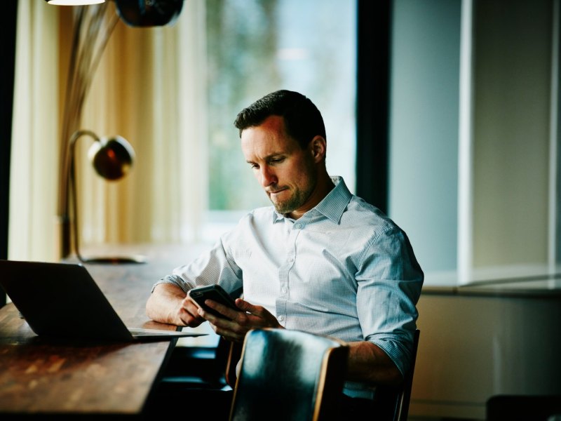 Grübelnder Mann mit Smartphone