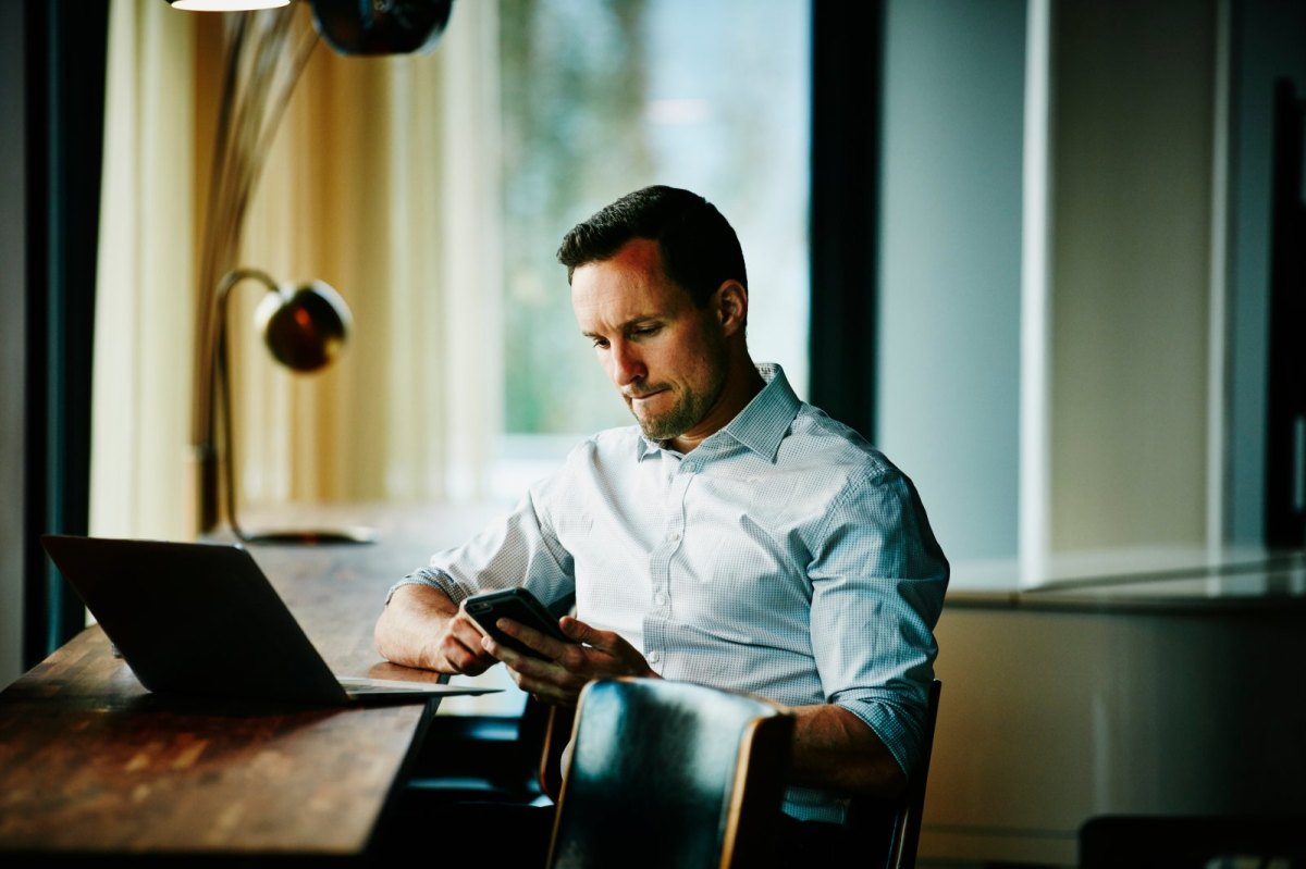 Grübelnder Mann mit Smartphone