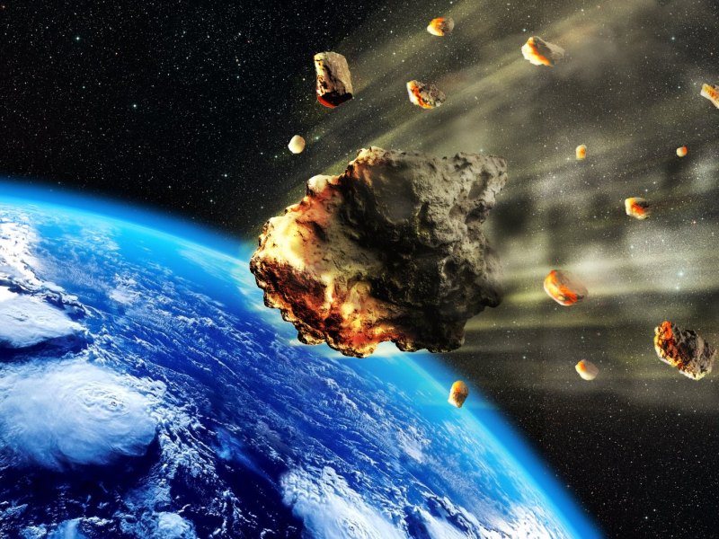 Asteroid im Weltall und im Hintergrund die Erde.