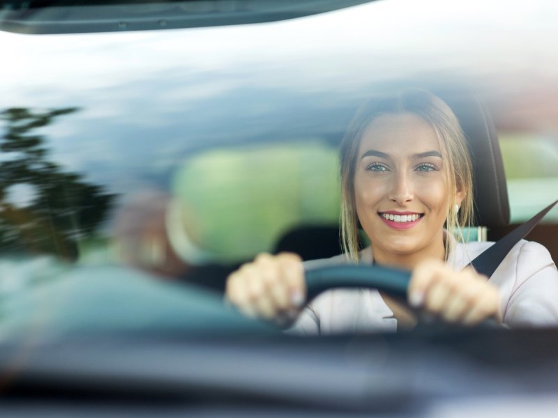 Junge Frau fährt Auto.