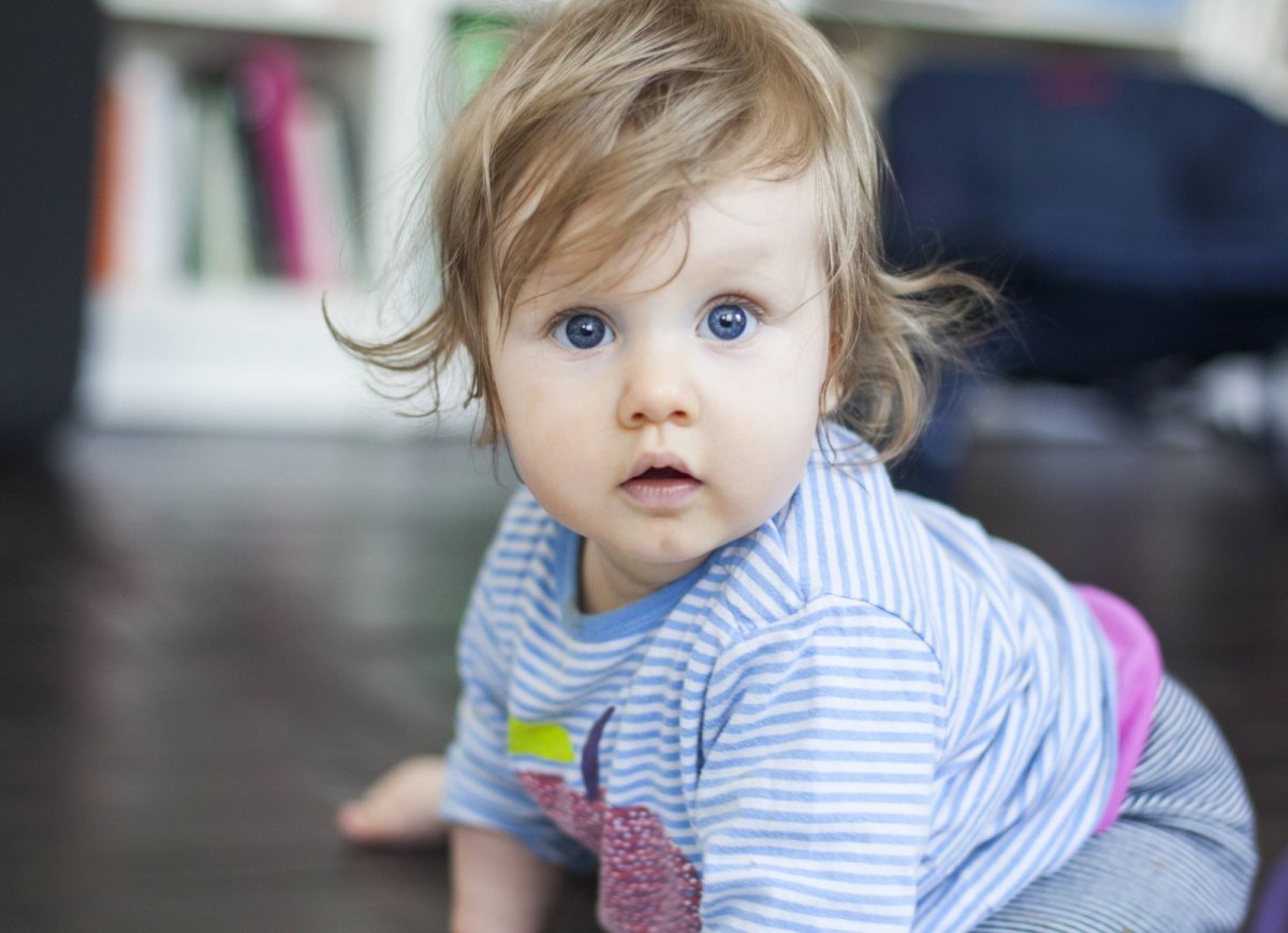 Ein Baby schaut erschrocken in die Kamera.