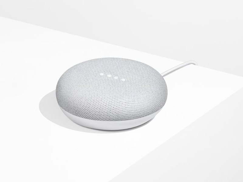 Ein Google Home Mini auf einem Regal.