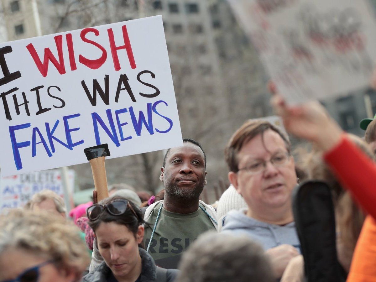 Mann hält ein Schild hoch mit: "I wish this was fake news".