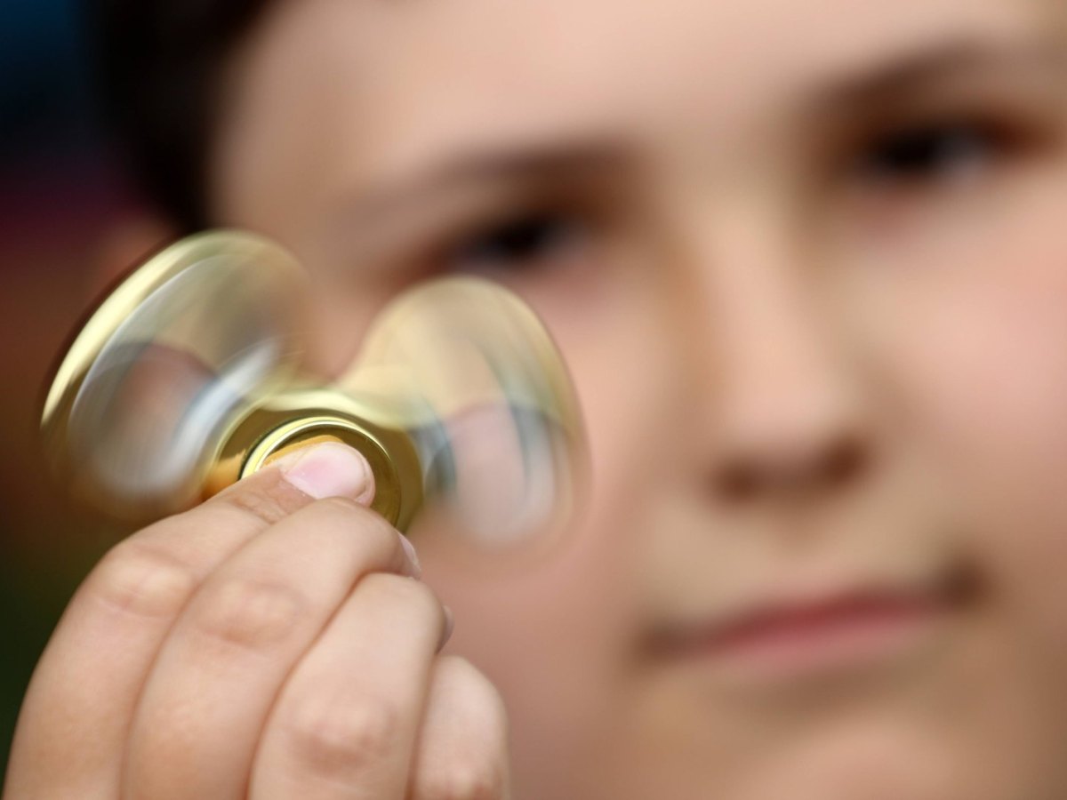 Ein Junge spielt mit einem Fidget Spinner