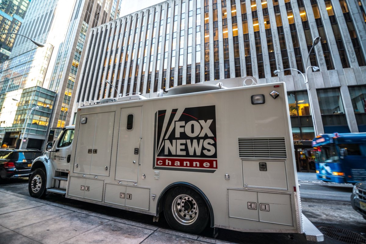 Fernsehertruck mit Fox News-Aufschrift vor einem Gebäude.