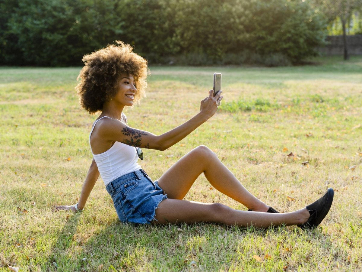 Frau fotografiert mit Handy.