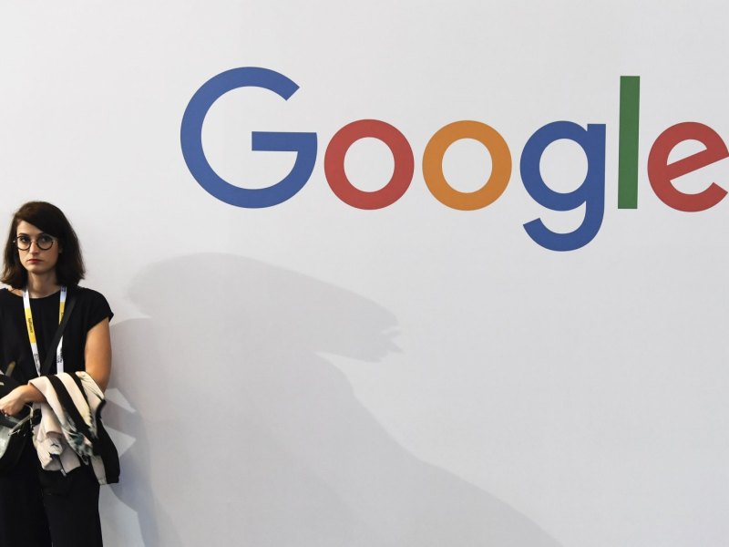 Frau steht neben dem Google-Logo