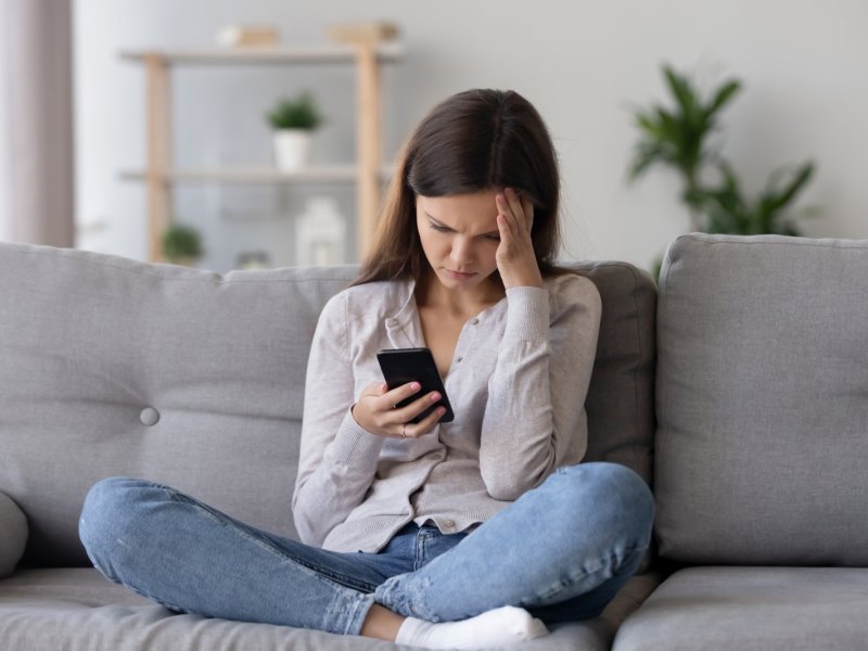 Frau auf dem Sofa mit Handy