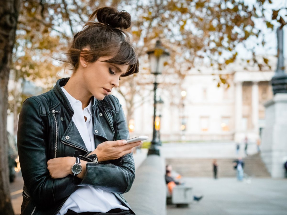 Frau schaut traurig auf ihr Handy