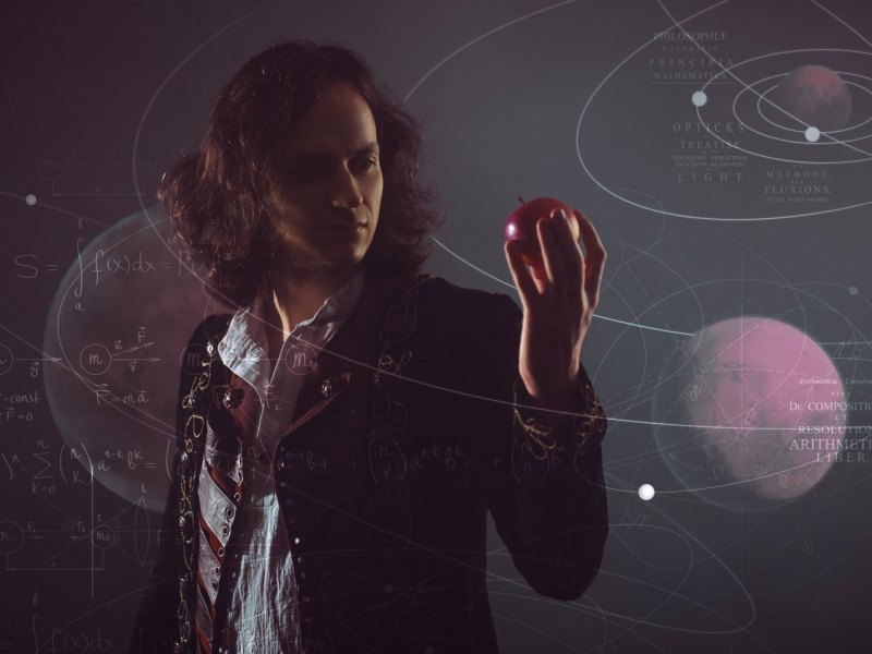 Isaac Newton mit einem Apfel in der Hand.