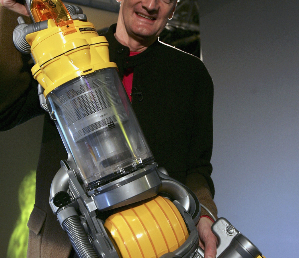 Dyson-Gründer James Dyson hält einen Dyson Staubsauger hoch