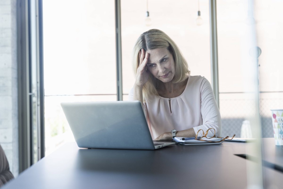 Frau guckt genervtg auf den Laptop