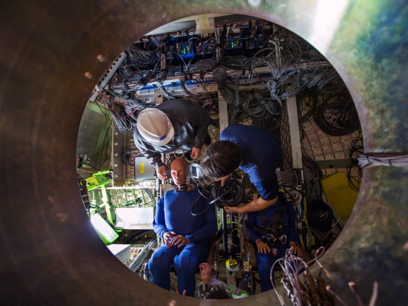 Ein Dummy der NASA wird für seinen Crash-Test in der nachgebildeten Orion-Kapsel vorbereitet.