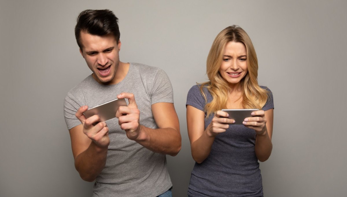 Mann und Frau spielen auf ihren Smartphones Handy-Spiele