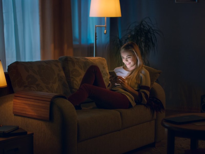 Frau auf dem Sofa mit Handy