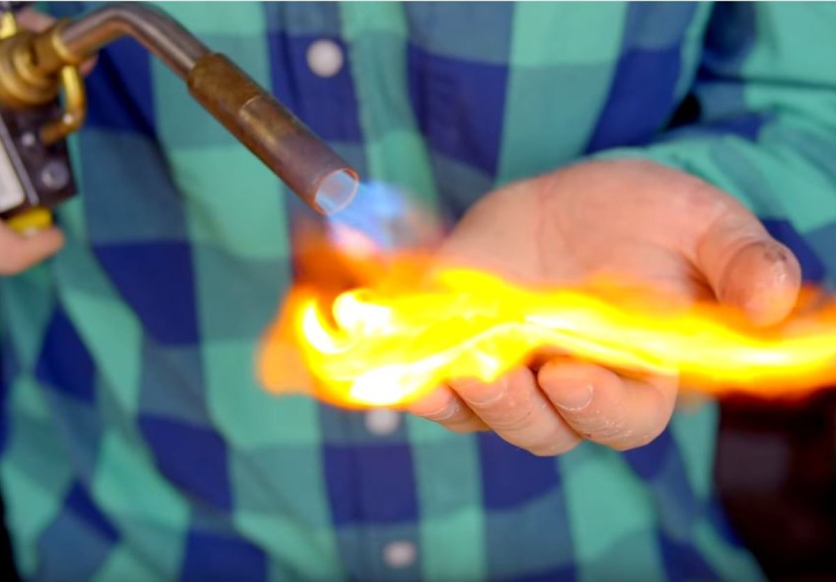 Hobby-Chemiker zündet Material auf seiner bloßen Hand an.