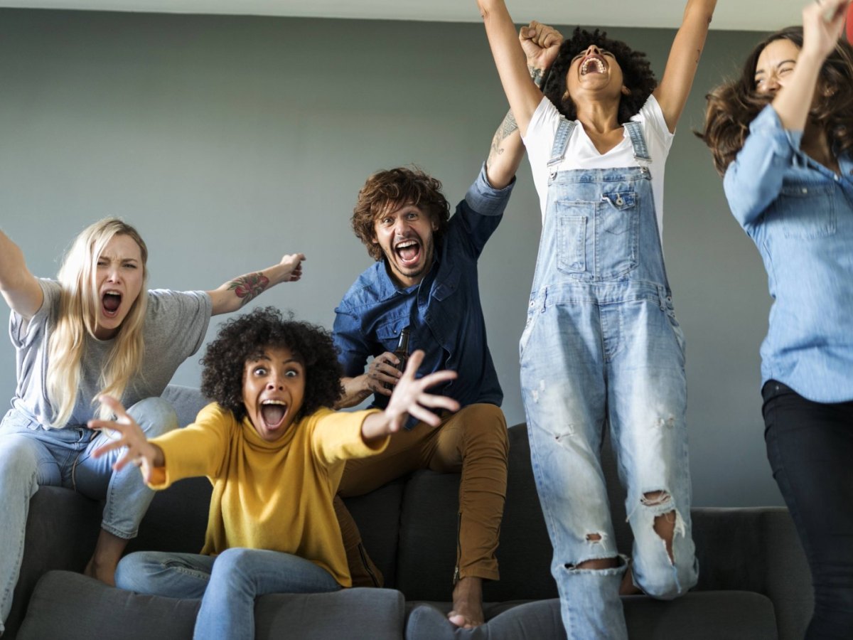 Gruppe von Freunden sitzt auf der Couch und brüllt.