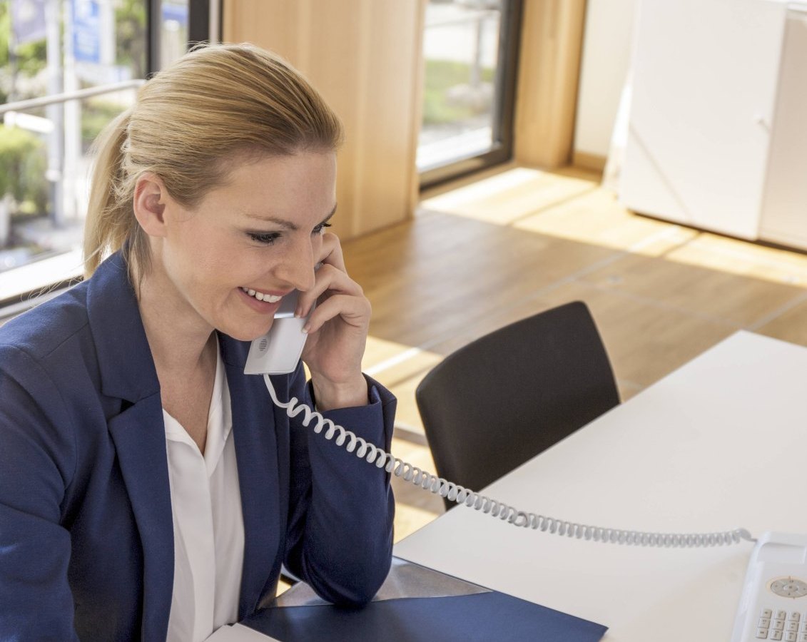 Frau beim Telefonieren am Schreibtisch