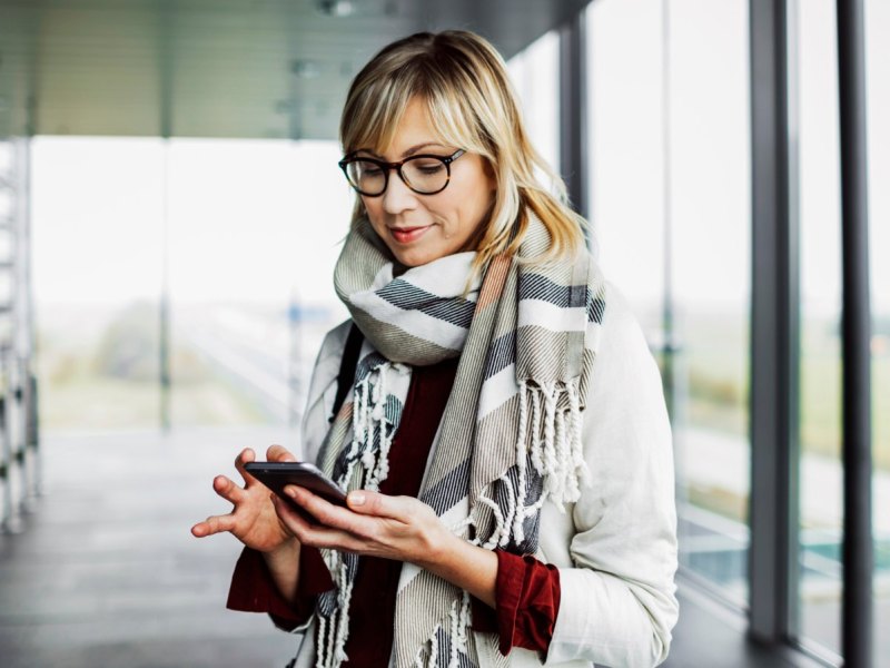 Frau mit Brille am Handy.