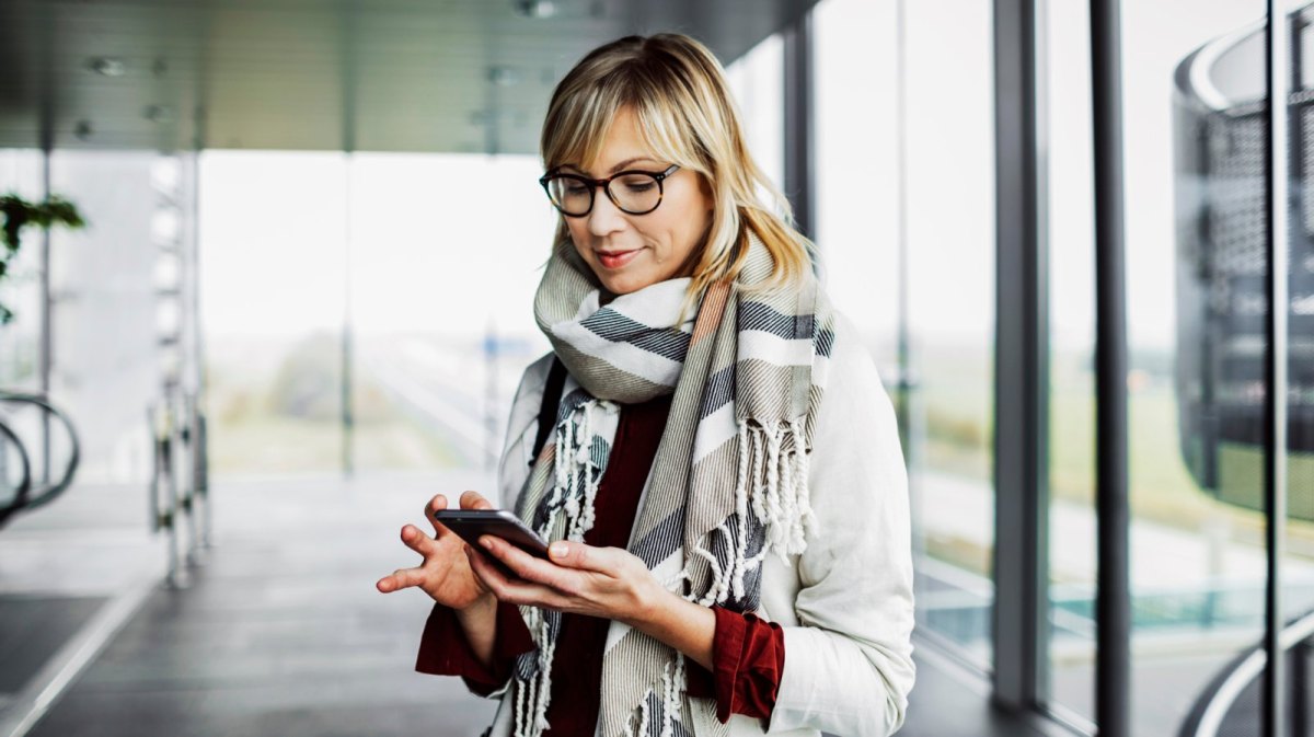 Frau mit Brille am Handy.