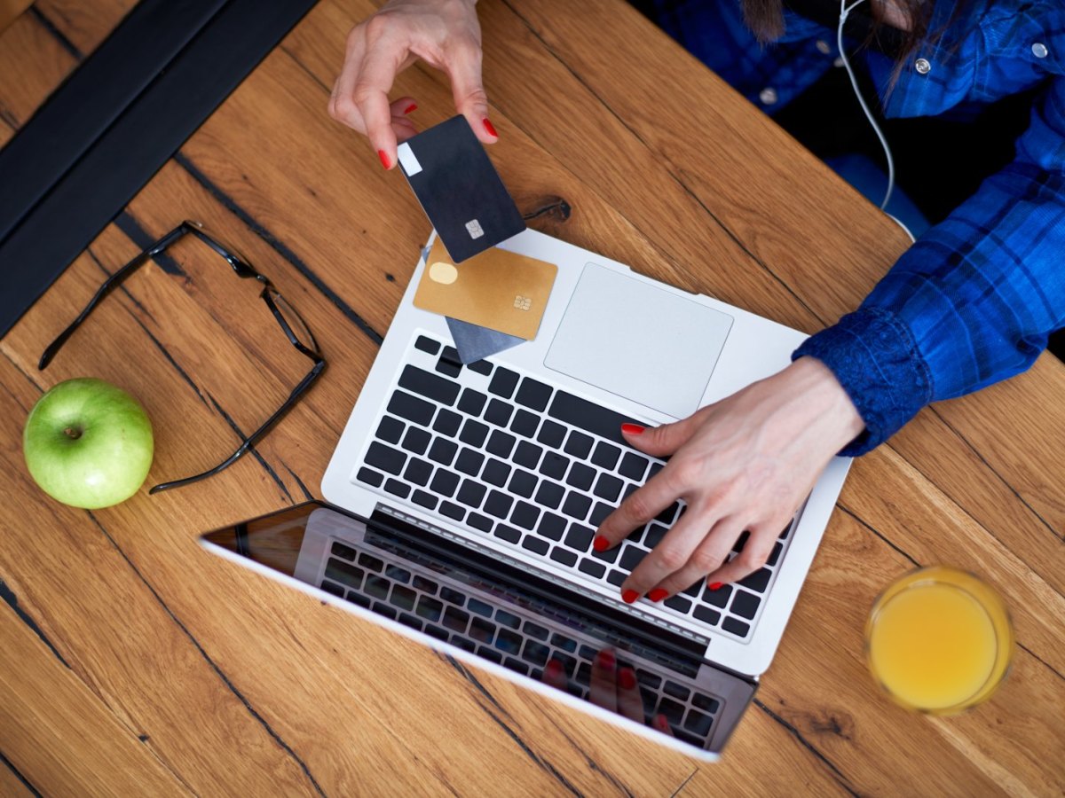 Frau mit Kreditkarten am Laptop.