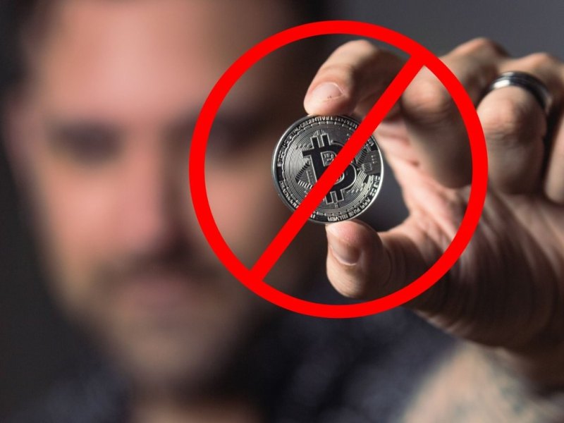 Mann hält Bitcoin in der Hand