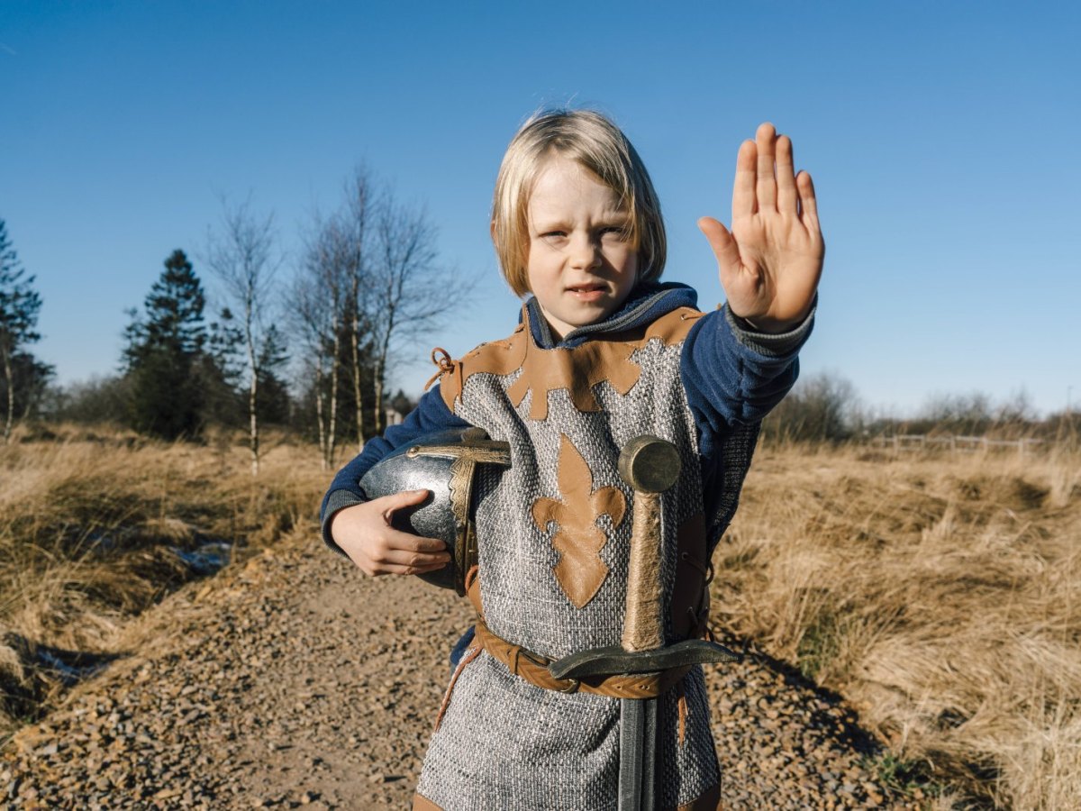 Kleiner Junge im Ritter-Kostüm hält die Hand zum Stop hoch