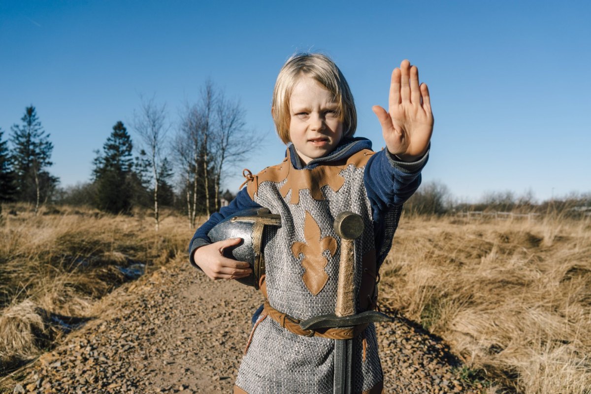 Kleiner Junge im Ritter-Kostüm hält die Hand zum Stop hoch