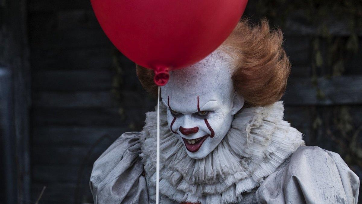 Bill Skarsgård als Pennywise mit einem roten Luftballon.