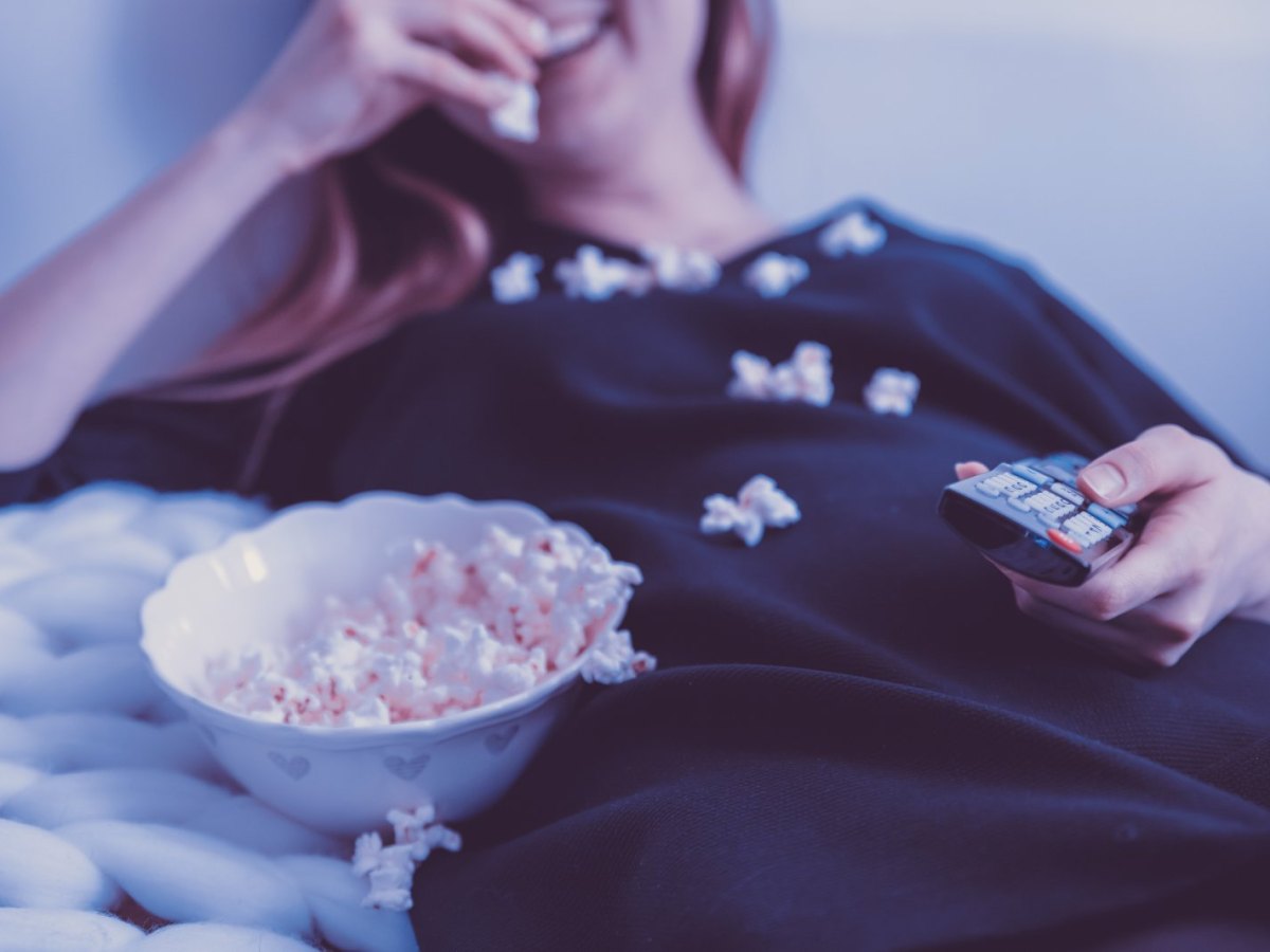 Frau schaut mit Popcorn Film