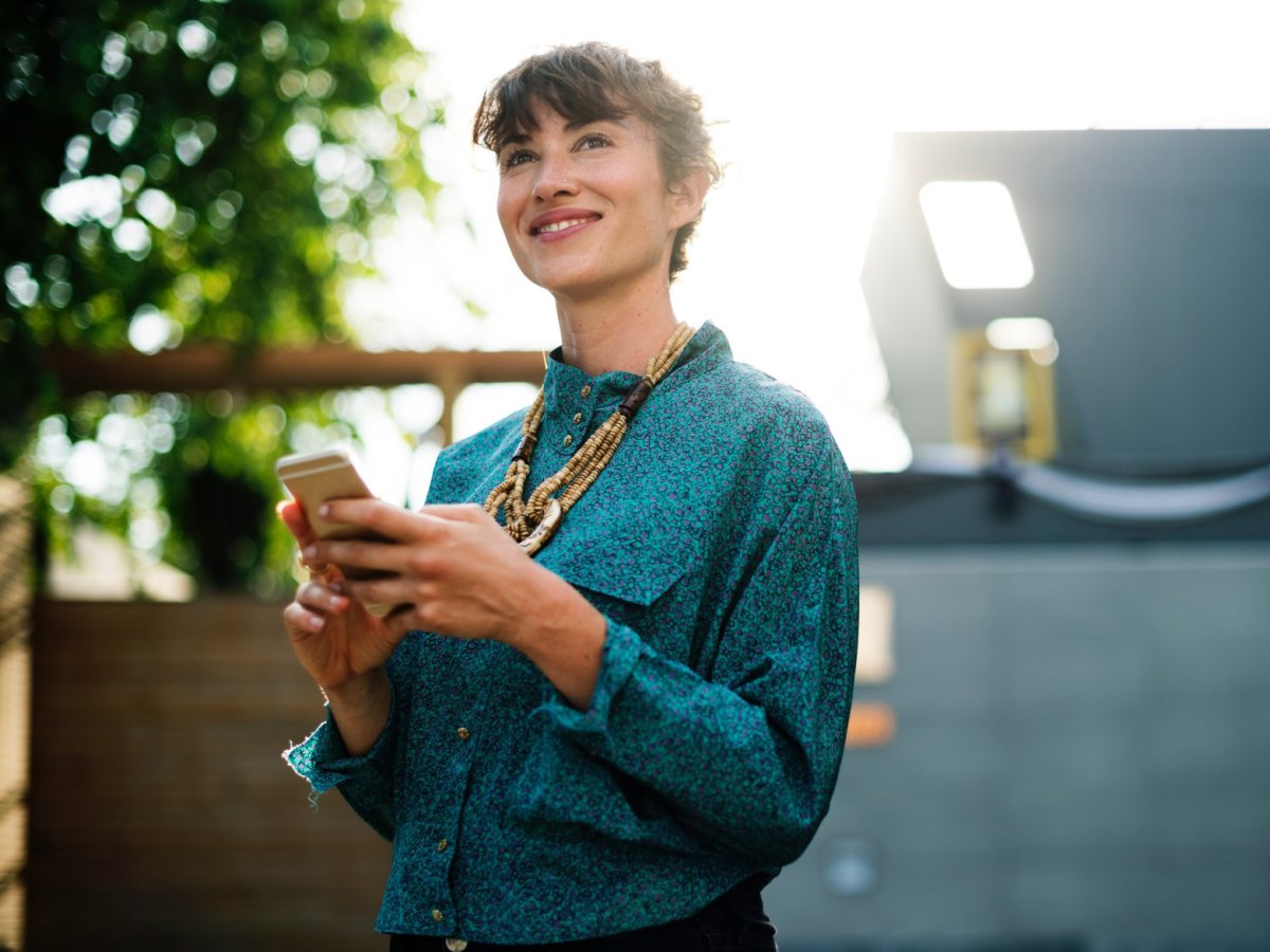 Glückliche Frau mit Handy in der Hand