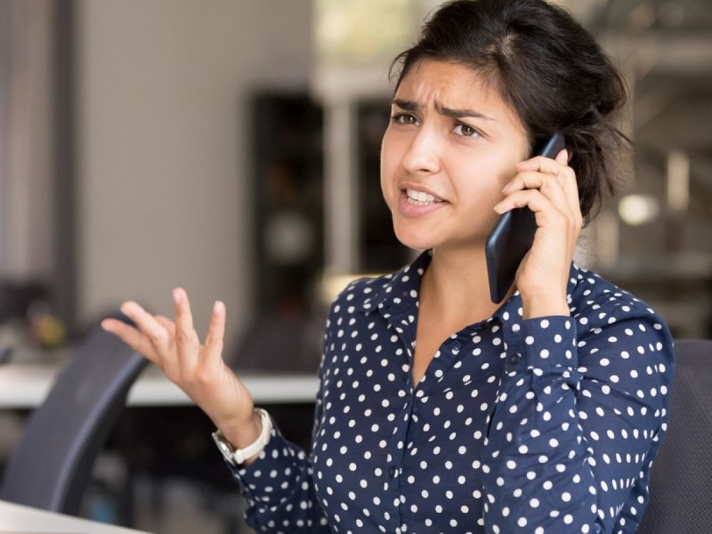 Frau telefoniert genervt am Handy.