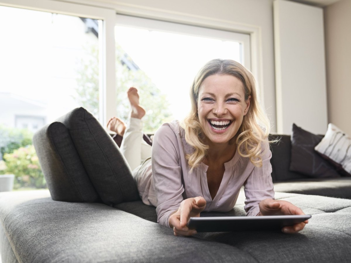 Frau am Tablet freut sich