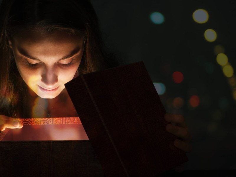 Frau schaut in Geschenkbox