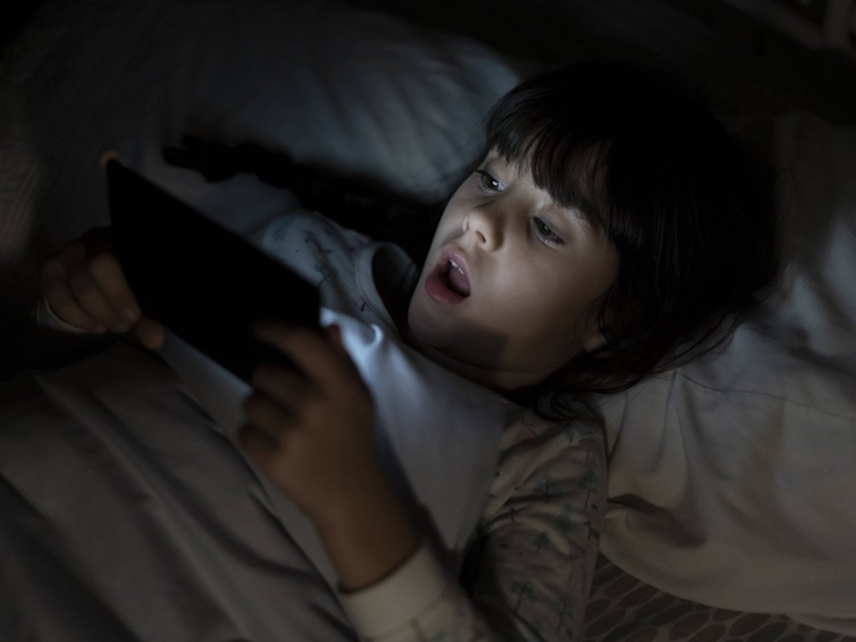 Mädchen im Bett mit einem Smartphone in der Hand