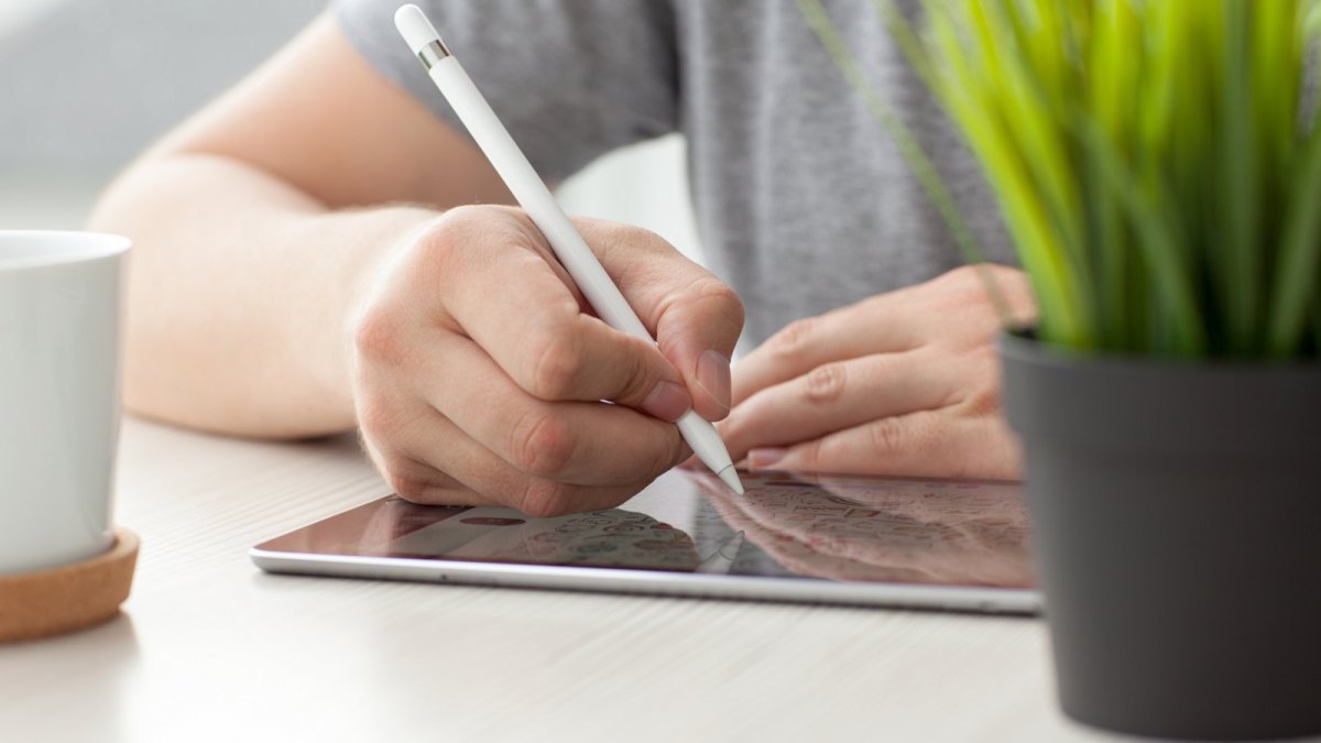 Person schreibt auf iPad