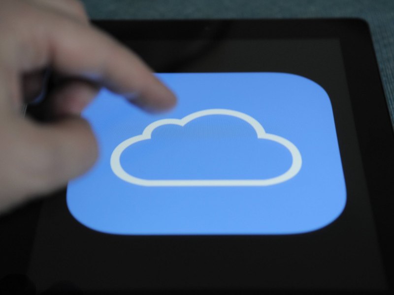 Person tippt auf das iCloud-Symbol