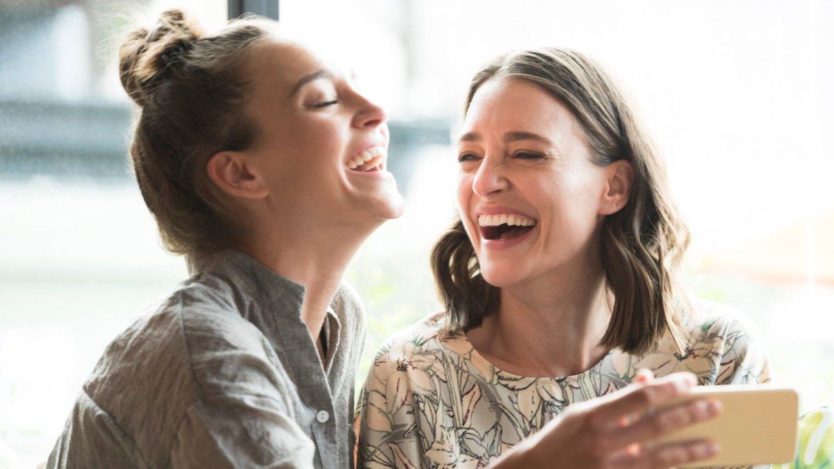 Zwei Frauen lachen mit Handy