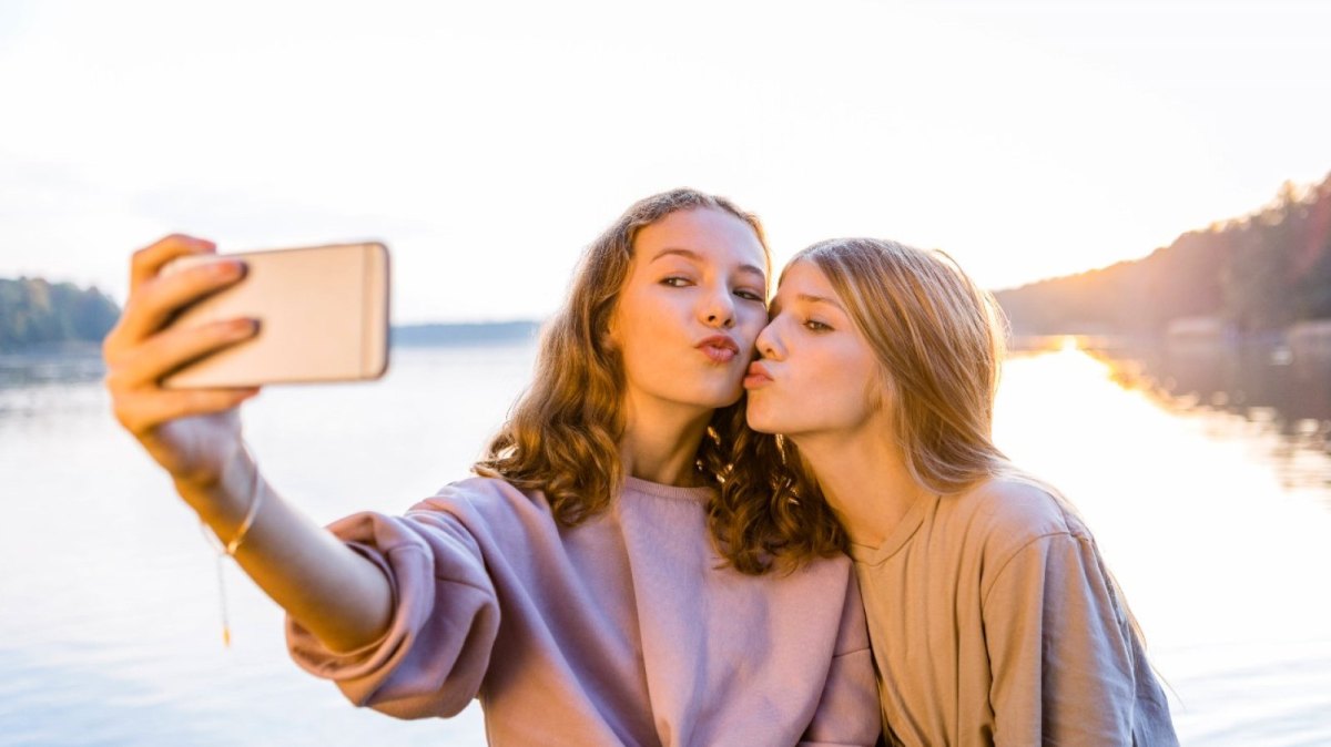 mädchen kussmund am see mit smartphone selfie