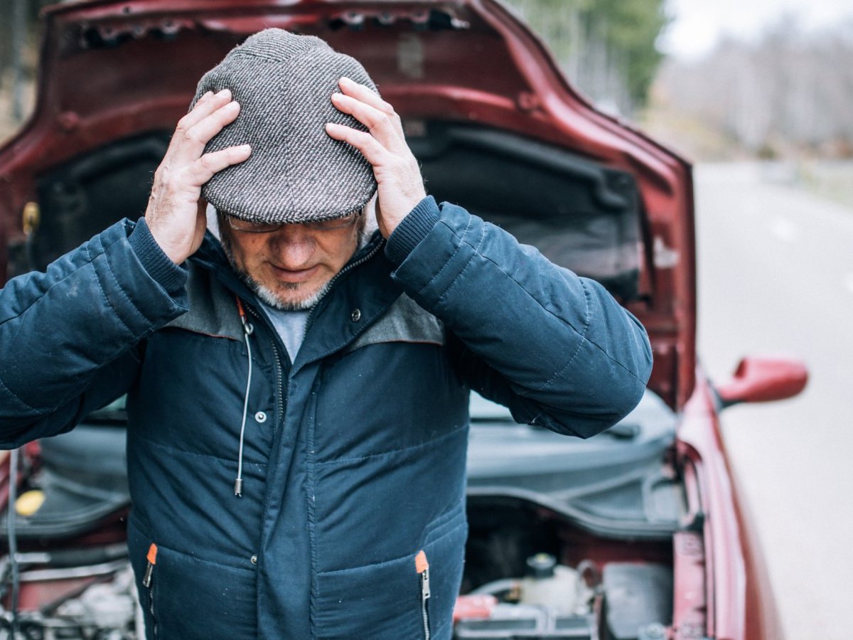 Mann vor offenem Motorraum