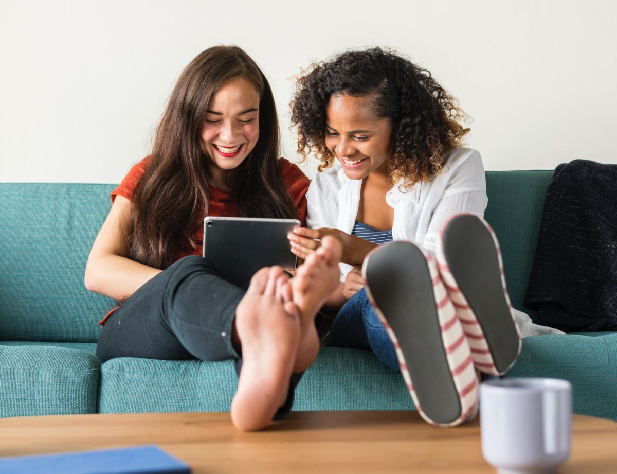 Zwei Personen lachen am Tablet