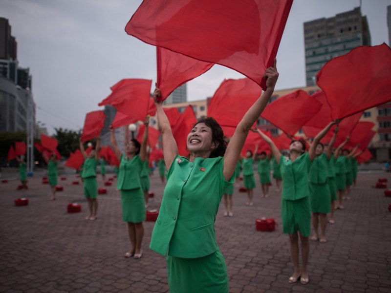 Frauen tanzen zu Propaganda-Zwecken mit Flaggen im nordkoreanische Pjöngjang.