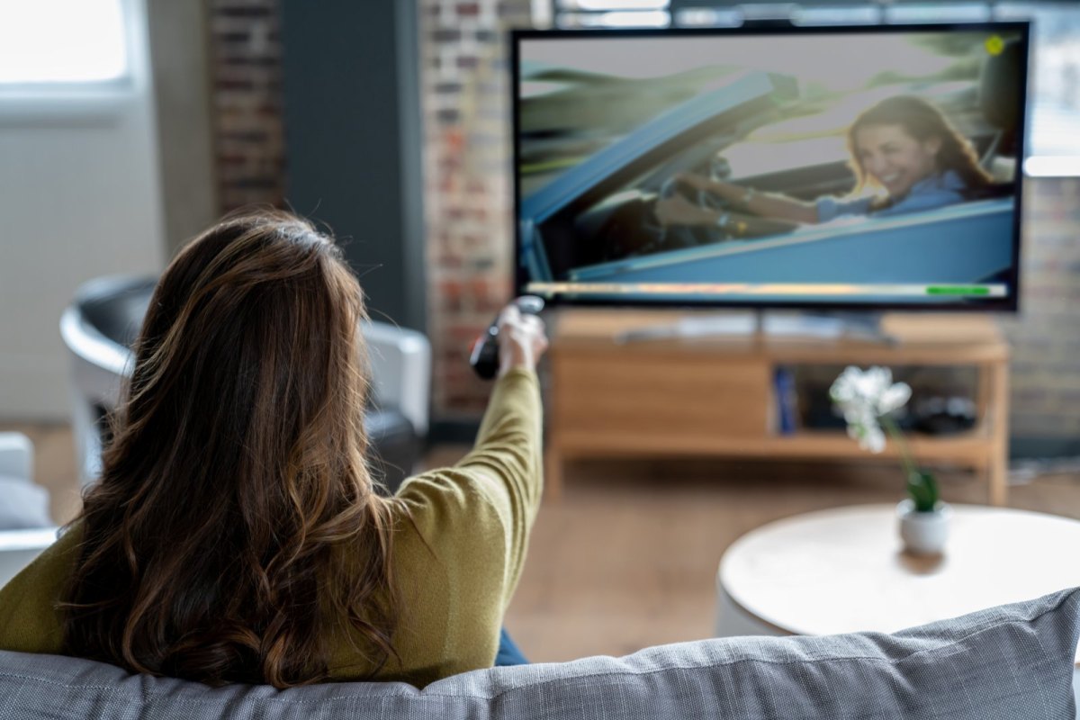 Frau sitzt vor dem Fernseher.