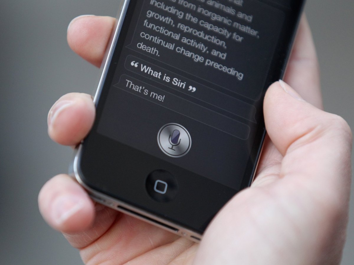 Hand hält iPhone mit Siri in der Hand