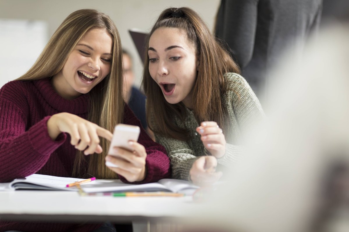 Junge Mädchen schauen erstaunt auf ein Smartphone