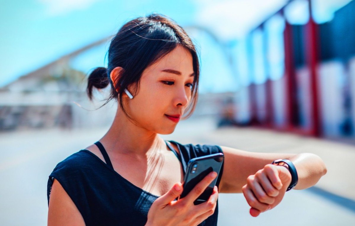 Frau mit Smartwatch und Kopfhörern