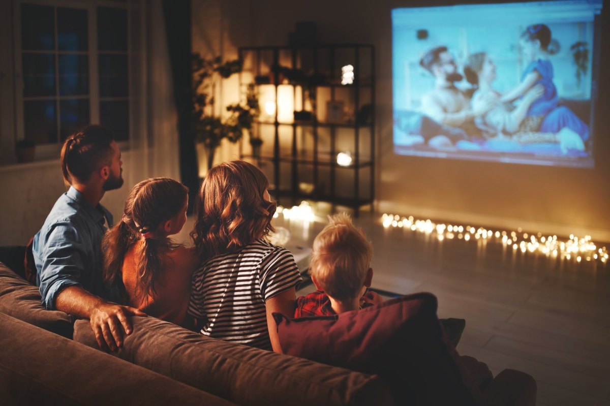 Eine Familie sitzt gemütlich vor dem Fernseher